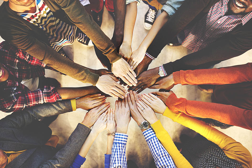 A Group Of People With All Their Hands In Forming A Circle